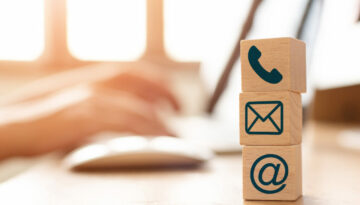 E-mail marketing concept, Hand using computer sending message with wooden cube block with icon mail address and telephone symbol